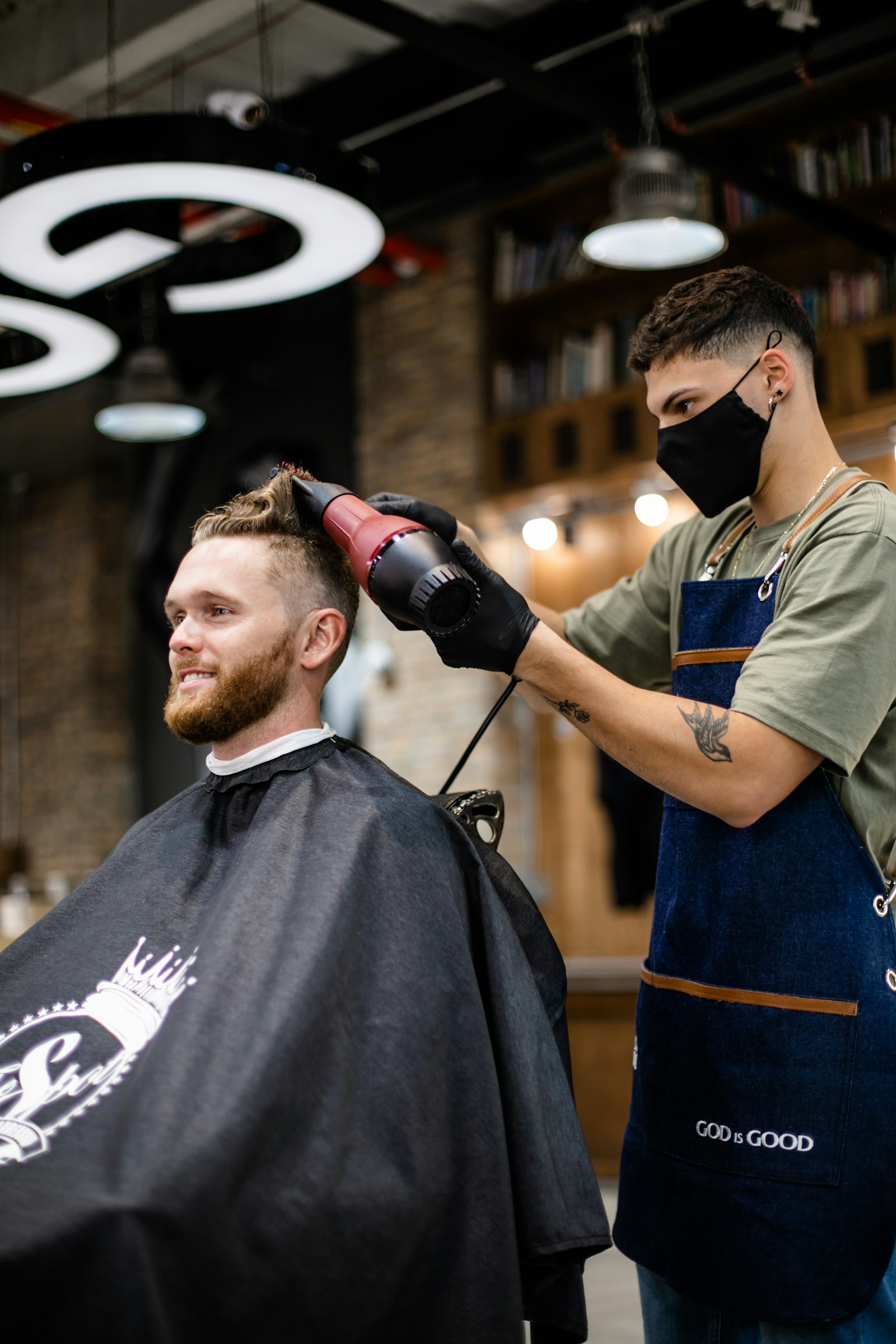 Barbero secando el pelo a un cliente